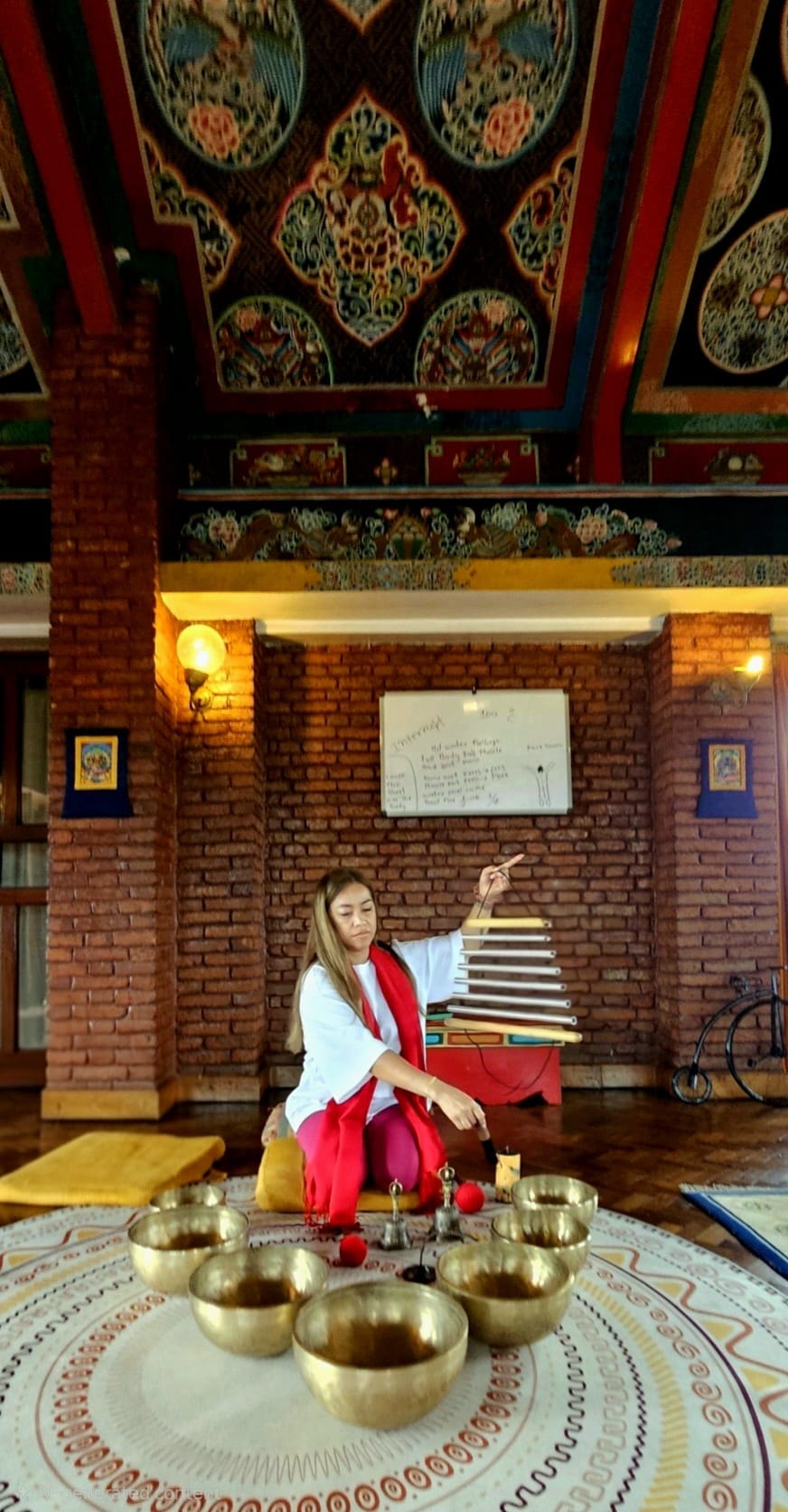 Wellness practitioner with singing bowls in a beautifully decorated space